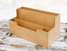 a wooden box with three compartments sitting on top of a table