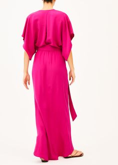 The Norma is a low v neck pink full length dress that features a plunging neckline with two concealed snaps to change the length of the neckline, half split sleeves, an elastic waist with a long wrap belt, and an asymmetrical skirt. This elegant silhouette is perfect for any formal event. Our pieces are majority made to order ensuring that no fabric is wasted and energy is conserved. Once the order is placed we will notify you when it has been made and is shipped out (Approximately 2-3 weeks). C Pink Belted V-neck Midi Dress, Pink Belted Dresses For Evening, Pink Belted Evening Dresses, Pink V-neck Dress With Surplice Neckline For Formal Occasions, Elegant Pink Belted Maxi Dress, Pink V-neck Dress With Side Slits, Draped Maxi Dress With Side Slits For Spring, Chic Pink Maxi Dress With Side Slits, Chic Long Dresses With Tie Waist