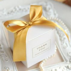 a white box with a gold ribbon on it