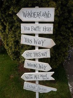 a wooden sign that says wonderland and tea party here this way not this way wrong way we all mad down here