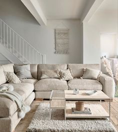 an instagram photo of a living room with couches, coffee table and stairs