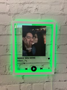 a green neon frame with an image of a man kissing a woman on the face