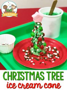 a christmas tree ice cream cone sitting on top of a green tray next to a cup