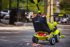 a yellow tricycle with a black bag on it's back sitting in the street