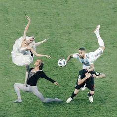 three people are playing with a soccer ball in the grass while one person is kicking it