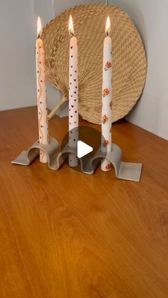 four candles are lit on a wooden table