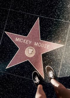 a person standing next to a star on the hollywood walk of fame with their feet up