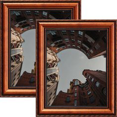 two brown framed pictures with buildings in the reflection