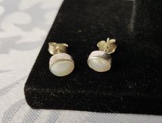 Simple sterling silver mother of pearl stud earrings. They are oval in shape with a raised white dome shaped mother of pearl inlay. They measure 1/3 inches long by 1/4 inches wide. There is a tiny defect in the MOP inlay on one of the earrings, it is about 2.5 mm long. See all the photos. I'll ensure your order is fulfilled as requested. Visit my shop at: newagainclassics.ca -Shipping times are taking longer due to the increase in online shopping- Silver Pearl Earrings, Mother Of Pearl, Gift, Silver Pearl Earrings With Mother Of Pearl As Gift, Silver Mother Of Pearl Earrings As Gift, Silver Mother Of Pearl Earrings For Gift, Oval White Pearl Earrings, Classic Mother Of Pearl Earrings As Gift, White Cabochon Earrings For Anniversary, Classic Mother Of Pearl Earrings For Gift, Gift White Hallmarked Pearl Earrings