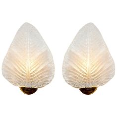 a pair of wall lights with leaf shaped glass shades on each light, one is gold and the other is white