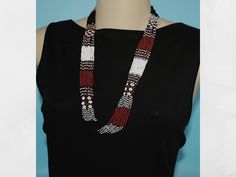 This striking necklace was hand beaded by one of our group of Mayan women in the village of Santiago Atitlan, Guatemala. This necklace's multiple strands are made from white, black and brick colored Czech beads.These beads form intricate patterns creating a stunning and unique look. This is a convenient "slips-over-the-head" necklace that does not require any closure clasps.  Each necklace is individually hand made; therefore there may be a slight variance in the placement and color of the natur Artisan Black Beaded Necklace Handwoven, Traditional Handwoven Black Necklace, Adjustable Black Handwoven Necklace, Traditional Multi-strand Black Beaded Necklaces, Brick Colors, Czech Beads, Multi Strand, Unique Necklaces, Hand Beading