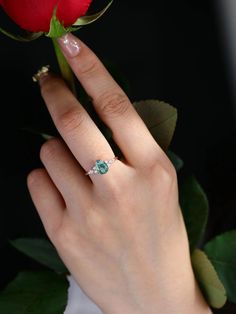 a close up of a person's hand with a rose in front of them