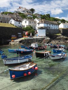 several small boats are tied up in the water near some houses and beachfronts