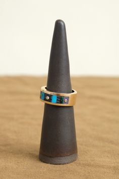 The Composition Inlay Ring is a handmade work of art from Young in the Mountains. Its distinctive band is adorned with a variety of stunning inlaid stones, including Turquoise, Black Dino Bone, Chrysocolla, and Burro Creek Jasper from Western America. Scattered throughout the inlay are reclaimed diamonds, further adding to the uniqueness and excellence of this exquisite piece. Artisan Rings With Inlay For Anniversary, Artisan Multi-stone Ring Jewelry, Artisan Multi-stone Ring, Modern Anniversary Rings With Inlay, Modernist Rings With Inlay For Gift, Modernist Rings With Inlay Perfect For Gifts, Elegant Turquoise Inlay Rings, Modernist Multi-stone Ring, Modernist Inlay Jewelry As Gift