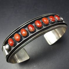 MARCELLA JAMES (NAVAJO) RED CORAL BRACELET DESCRIPTION:  This lovely bracelet will be a cherished addition to your collection of fine vintage Southwestern and Native American jewelry. MEASUREMENTS: Interior of the cuff measures 5 1/2" with an additional 1 1/8" slightly adjustable gap. Total circumference:  6 5/8" Measures 2 3/8" straight across the widest part  (from wrist bone to wrist bone) Bracelet face measures  5/8" wide (the face of the bracelet, north to south) WEIGHT:  24.0 grams SIGNED: Adjustable Red Oval Bracelet, Adjustable Red Oval Bracelets, Vintage Red Jewelry With Polished Finish, Classic Handmade Cuff Bracelets, Classic Handmade Cuff Bracelet, Red Southwestern Cuff Bracelet As Gift, Red Southwestern Cuff Bracelet Gift, Red Adjustable Vintage Cuff Bracelet, Vintage Red Adjustable Cuff Bracelet