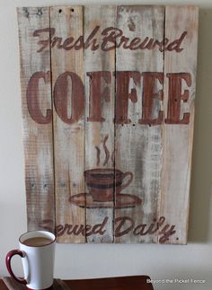 a cup of coffee sitting on top of a wooden table next to a sign that says fresh blend coffee