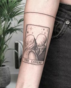 a tattoo on the arm of a woman with an image of two people hugging each other