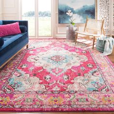 a living room filled with furniture and a pink rug