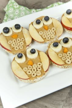 some food is on a white plate with blueberries and apples in the shape of an owl