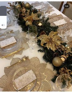 the table is set for christmas dinner with gold decorations