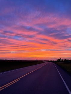 the sun is setting on an empty highway