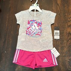 New With Tags! Toddler Girl Adidas Athletic Set. Gray T-Shirt With Pink/Blue/Green/Purple “Adidas” Design; And Bright Pink Shorts With Light Purple Stripes On The Sides. Size 18 Months. 60% Cotton/40% Polyester. Pink Graphic Print Sets For Playwear, Adidas Pink Playwear Sets, Adidas Casual Tops For Playwear, Casual Adidas Tops For Playwear, Pink Adidas Cotton Set, Adidas Pink Sets For Spring, Adidas Pink Cotton Sets, Adidas Pink Spring Set, Pink Cotton Adidas Sets