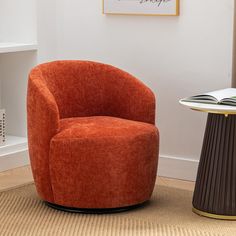 an orange chair sitting next to a table with a book on it's side