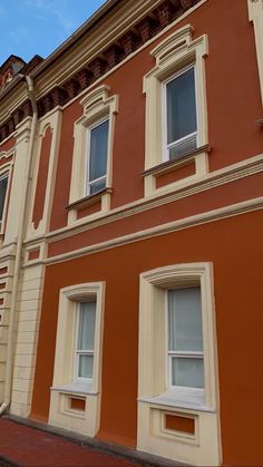 an orange building with white windows and a clock