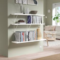 a living room filled with furniture and bookshelves next to a white couch in front of a window