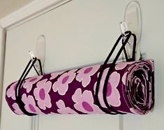 a pink and purple flowered yoga mat hanging from a hook