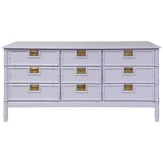 a white dresser with wicker drawers and gold handles on the bottom, against a white background