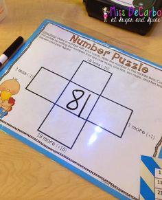 the number puzzle is displayed on a table with markers and pens next to it,