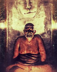 an old man sitting in front of a buddha statue