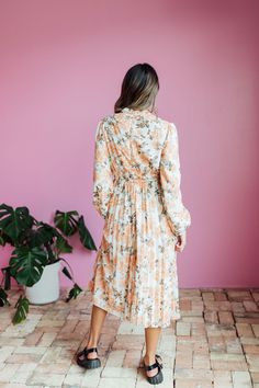 The Oakley Midi dress in a cream base with a peach and brown rose floral design is both stylish and functional. With a high neck, zipper in the back, and long sleeves with elastic cuffs, this dress is comfortable and easy to wear. The elastic waist with a tie creates a flattering silhouette, while the pleated bottom adds a touch of elegance. Model is wearing a small and is 5'8". Plus model is wearing a 2X and is 5'11". Size Chart Length Bust Waist S 47" 34" 32" M 47" 37" 34" L 47.5" 40" 36" XL 47.5" 44" 38" XXL 48" 48" 41" XXXL 48.5" 52" 44" *Measurements are approximate and are measured while hanging* Fabric and Care 100% Polyester Hand wash cold. Do not bleach. Lay flat to dry. Low iron if needed or dry clean. Tiered Dresses, Plus Model, Teen Dress, Hanging Fabric, Cream Base, Spring Fits, White Outfits, Jeans Dress, Floral Maxi Dress