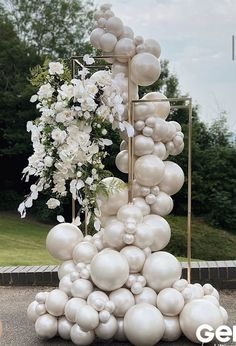 an arrangement of balloons and flowers on display