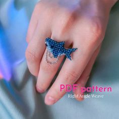 a woman's hand wearing a ring with a blue star design on the middle