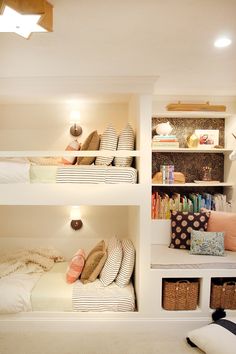 three bunk beds in a small room with white walls and carpeted flooring, along with bookshelves