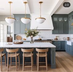 a large kitchen with blue cabinets and white counter tops is featured in this article by interior stylist