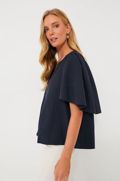 The Finley Flutter Sleeve Top is effortlessly chic. In a classic navy hue, this blouse has a flattering silhouette, oversized flutter sleeves, and a V-neckline that is perfect for year round wear. Pair with gold accessories for everything from work to brunch this season. V-neckline Oversized short flutter sleeves Boxy fit Slightly cropped Material: 100% Cotton Care: Hand wash cold, hang to dry Chic Flutter Sleeve Blouse For Work, Chic Ruffle Sleeve Tops For Work, Navy Elegant Tops For Formal Occasions, Elegant Navy Short Sleeve Tops, Chic Workwear Blouse With Flutter Sleeves, Navy Elegant Formal Tops, Blue Flutter Sleeve Tops For Work, Blue Flutter Sleeve Tops For Workwear, Elegant Flutter Sleeve Blouse For Work