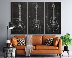 a living room with a couch and two guitars on the wall