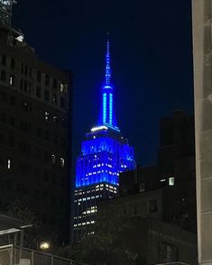 the empire building is lit up in blue and white