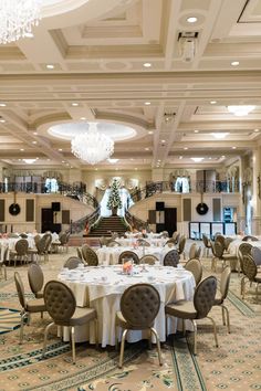 an elegant dining room with chandeliers and tables set up for a formal function