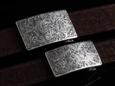 One of our most popular buckles, this understated piece by Comstock Heritage is perfect for those just starting their buckle collections, or for more formal occasions. It’s made from heavy-gauge, hand-engraved Sterling silver, and its rectangular face is adorned with beautiful, delicate scrollwork. This buckle can be paired easily blue jeans or be worn with dressier slacks. This buckle comes in two sizes as well. First smaller size measures approx. 1 5/8" x 2 5/8" and fits all 1.25" belt traps S Luxury Formal Jewelry With Silver Buckle, Classic Formal Belt Buckle Rectangular, Classic Formal Belt With Tang Buckle, Classic Belts With Tang Buckle, Luxury Engraved Silver Belt Buckles, Classic Belts With Tang And Rectangular Buckle, Elegant Tang Buckle Belt Buckles For Formal Wear, Luxury Formal Belt With Tang Buckle, Classic Rectangular Buckle Belt