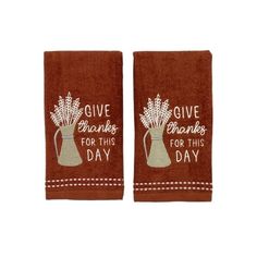 two brown towels with words on them and flowers in vases that say give thanks for this day