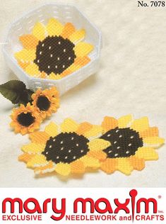 two plastic sunflowers sitting next to each other in front of a white box