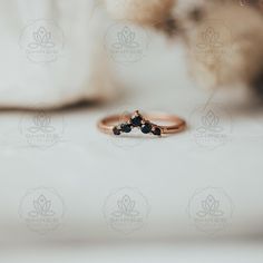 a close up of a ring on a white surface with some flowers in the background