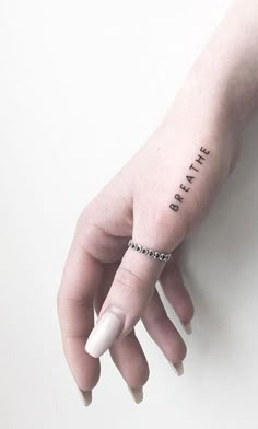 a woman's left hand with a small tattoo on the wrist that says believe