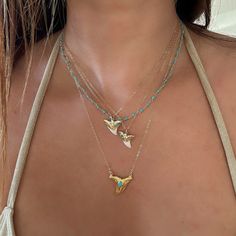 Turquoise Shark Tooth Necklaces. We know you will want to swim in the ocean with your shark tooth necklace so we used waterproof vermeil gold for this piece, and we always use authentic stones, so our turquoise is 100% real Arizona turquoise.The shark teeth we use are found on the shores of Florida and are all a bit different in size and shape. You will receive one shark tooth necklace. Gold with turquoise and white tip. Some photos show other pieces as layering options and styling inspiration. Gold Summer Jewelry, Gold And Turquoise Jewelry, Swim In The Ocean, Surf Jewelry, Beachy Jewelry, Pretty Jewelry Necklaces, Shark Tooth Necklace, Tooth Necklace, Gold Girl