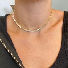 We took everyone’s favorite, the Tennis Choker, and enhanced the design. Adorn your neck with this gold-plated spectacular stunner. This sophisticated Tennis Choker is custom-cut in sleek crystal clear cubic zirconia 4mm stones. The delicate yet durable clasp fits perfectly on your collarbone because it comes in adjustable sizing. This tennis choker will take you everywhere from day to night. Designed to perfection in Montreal, Canada. All our products are of high quality, long-lasting, and resi Gold Crystal Tennis Necklace With Sparkling Stones, Elegant Gold Tennis Necklace With Rhinestones, Gold Diamond Tennis Necklace With Accents, Gold Dazzling Tennis Necklace With Brilliant Cut, Gold Bling Tennis Necklace For Gift, Gold Tennis Necklace With Diamond Accents And Crystal, Elegant Iced Out Diamond Necklace, Gold Tennis Necklace With Rhinestones, Gold Tennis Necklace With Rhinestones And Cubic Zirconia