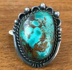 "VINTAGE NAVAJO TURQUOISE RING DESCRIPTION: This ring features a hefty specimen of Pilot Mountain turquoise. The gemstone is secure in smooth bezel, on a foundation of heavy gauge vintage sterling silver. This ring will be a treasured addition to your collection of fine vintage Native American jewelry. MEASUREMENTS: Ring face measures 1 5/8\" x 1 1/4\" Cabochon measures 32mm x 22mm RING SIZE: 8 1/4 WEIGHT: 22.6 grams SIGNED: no (Navajo) STERLING: yes, stamped STERLING" Vintage Collectible Rings With Large Stone, Vintage Rings With Large Stone For Collectible, Vintage Rings With Large Stone For Collectors, Classic Collectible Round Turquoise Ring, Vintage Round Rings With Large Stone, Vintage Oval Ring With Patina, Vintage Turquoise Ring With Large Oval Stone, Vintage Oval Turquoise Ring With Large Stone, Vintage Oval Rings With Large Stone